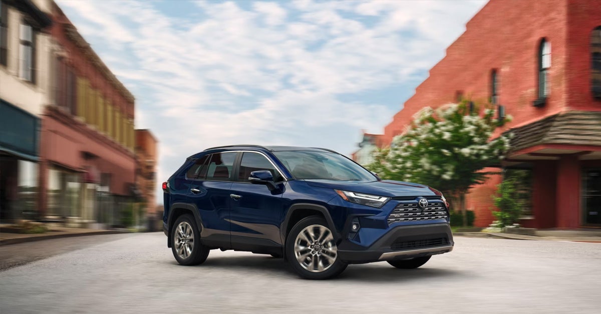 A blue SUV is parked on a quiet street.